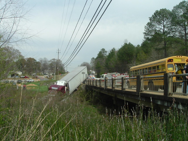 Truck accident scene with school bus and emergency traffic